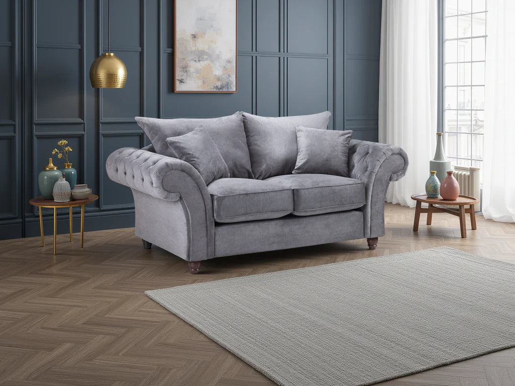 Gray sofa in a living room with dark blue paneled walls and light wooden flooring.